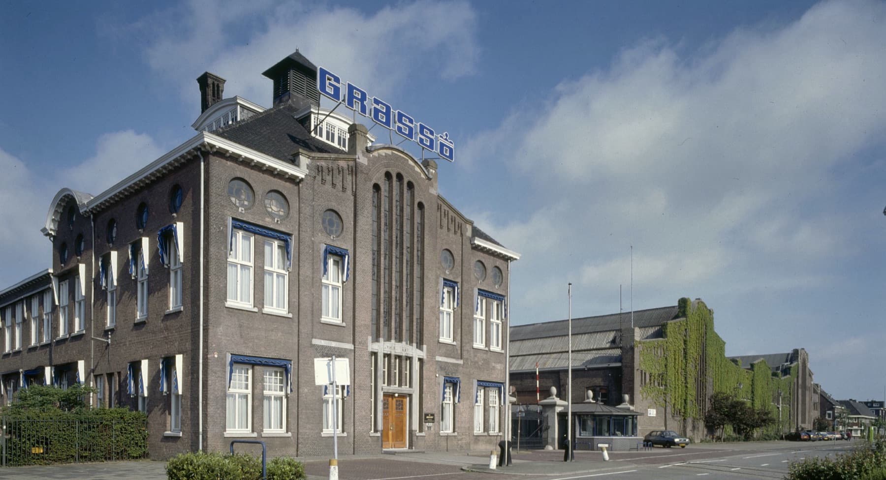 Het administratiegebouw van machinefabriek Grasso aan de Parallelweg in 's-Hertogenbosch, met het Grasso-bord op het dak